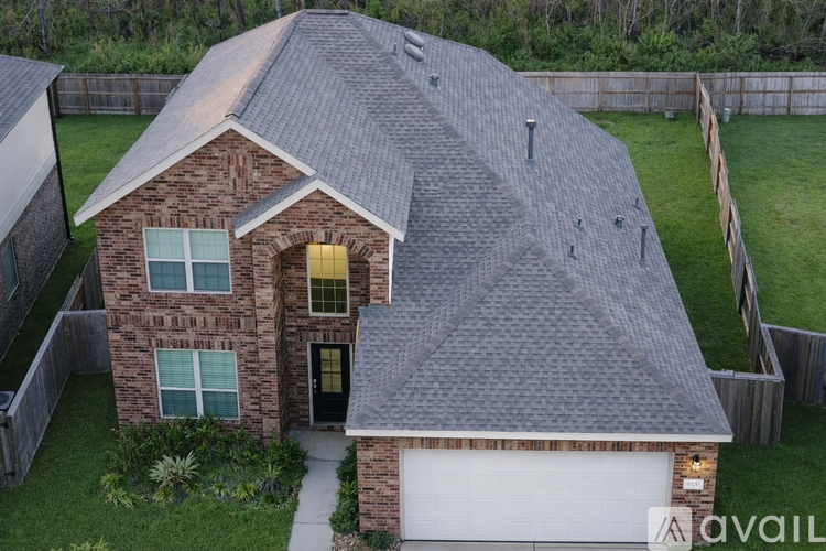 A house with a grey roof and a white garage door.