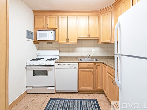 A kitchen with wooden cabinets and white appliances.