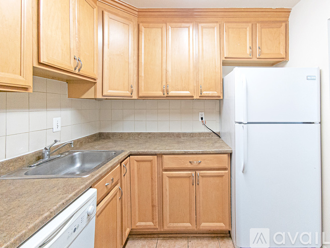 A kitchen with wooden cabinets and a white refrigerator.