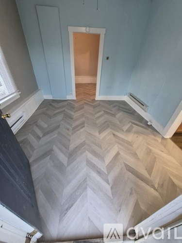 A hallway with a chevron patterned floor.