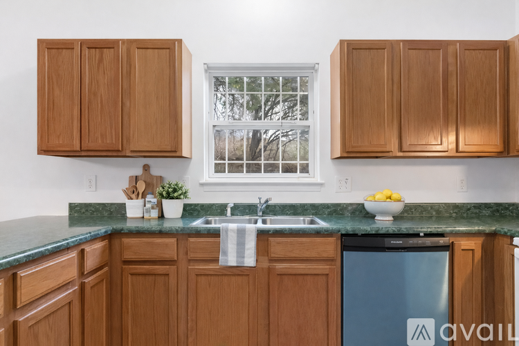 A kitchen with wooden cabinets and a blue dishwasher.