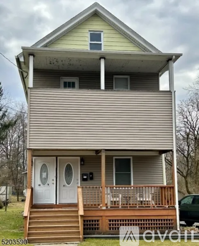 A two-story house with a porch and a balcony.