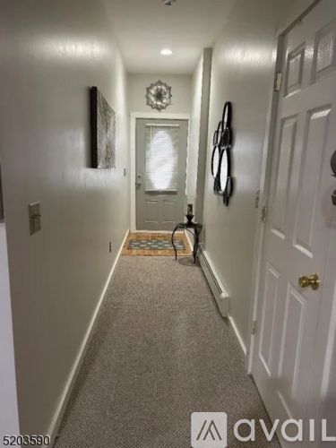 A hallway with a door and a wall hanging.