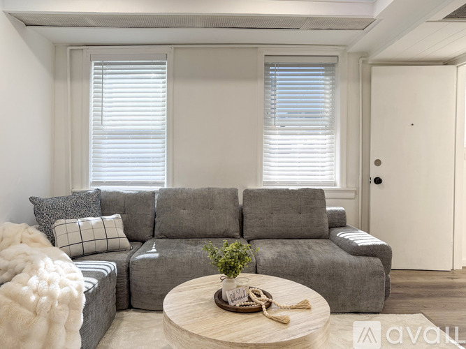 A living room with a grey sofa and a wooden coffee table.