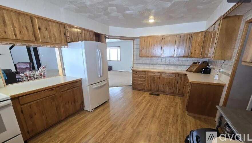 A kitchen with wooden cabinets and a white refrigerator.