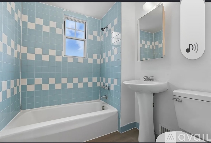 A bathroom with blue and white tiles and a white bathtub.
