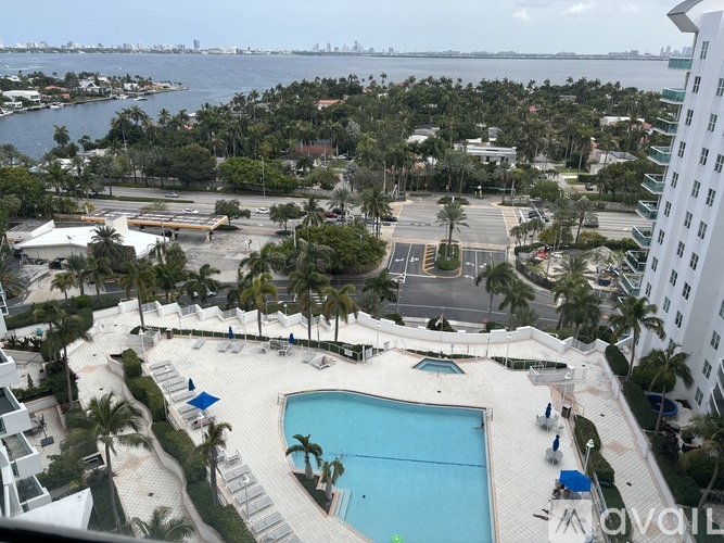 A view of a pool and beach from a high rise building.