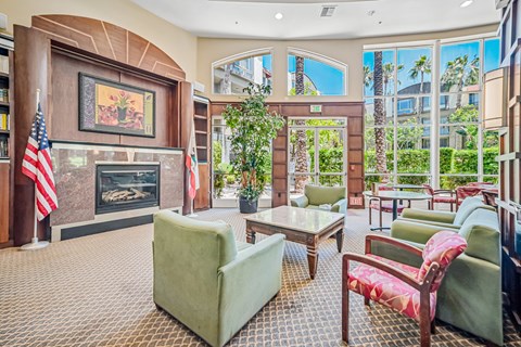 A living room with a fireplace and a painting of a palm tree on the wall.