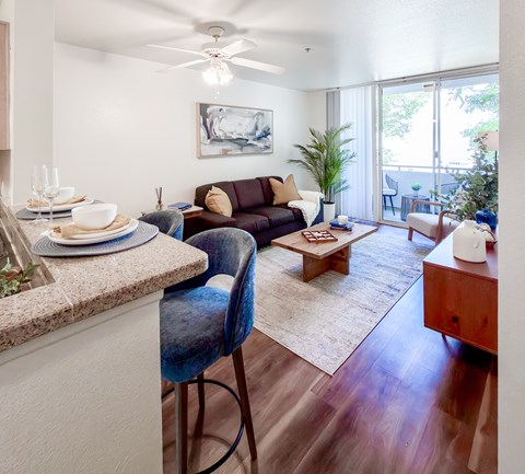 A modern living room with a brown couch and a dining table.