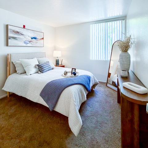 A bedroom with a large bed and a painting on the wall.