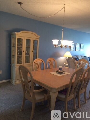 A dining room with a wooden table and chairs.