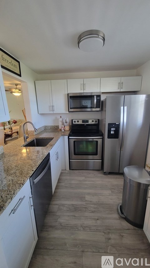 A kitchen with a refrigerator, oven, and sink.
