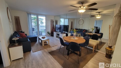 A living room with a dining table and chairs, a sofa, and a ceiling fan.