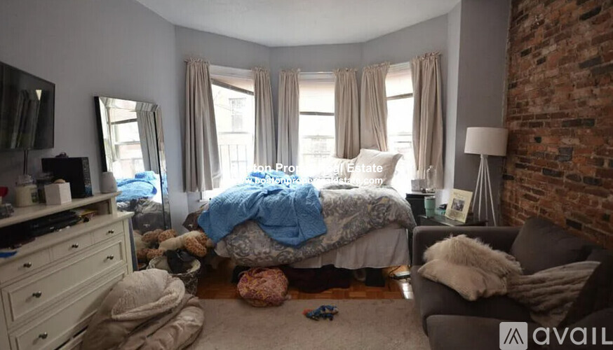A bedroom with a bed in the middle of the room.