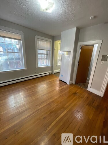 A room with wooden floors and a door on the right.