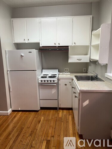 A kitchen with white appliances and cabinets.