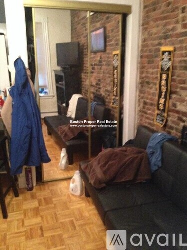 A living room with a couch, a TV, and a wall with a plaque on it.