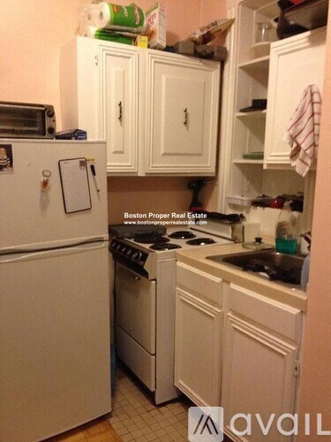 A kitchen with white appliances and cabinets is shown.