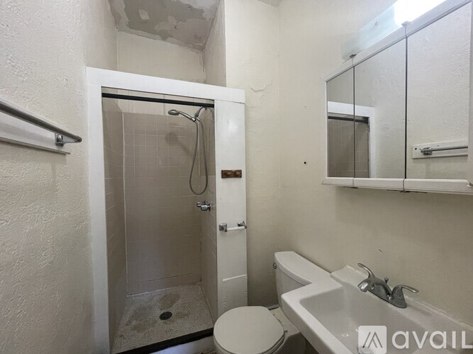 A bathroom with a toilet, sink, and shower.
