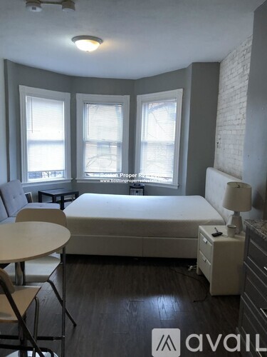 A bedroom with a bed, desk, and chair.