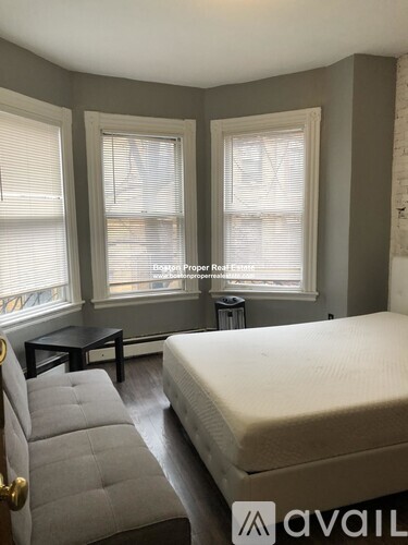 A bedroom with a bed, chair, and table.