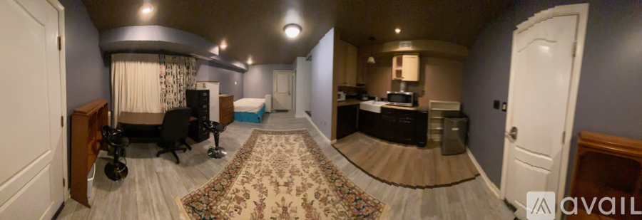 A bedroom with a bed, chair, and a couch.
