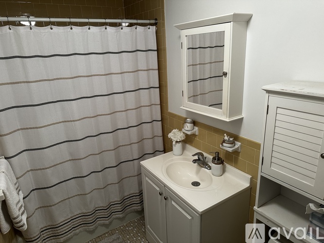 A white sink with a cabinet above it in a bathroom.
