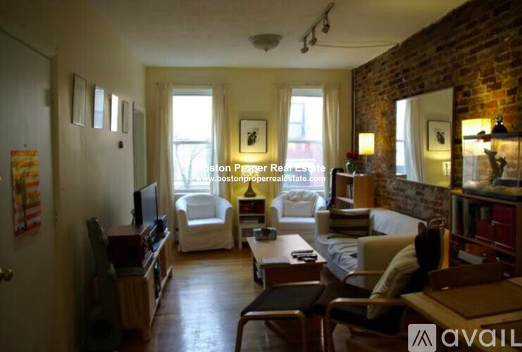A living room with a brick wall and a couch.