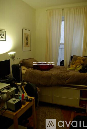 A bedroom with a bed, desk, and chair.