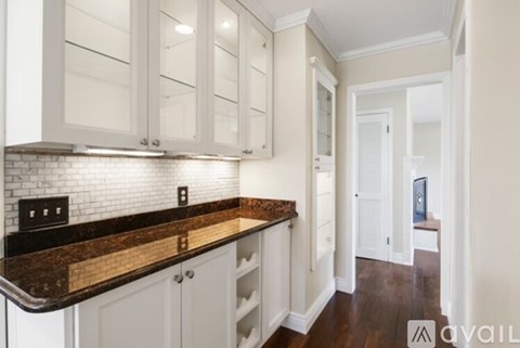A kitchen with white cabinets and a brown countertop.