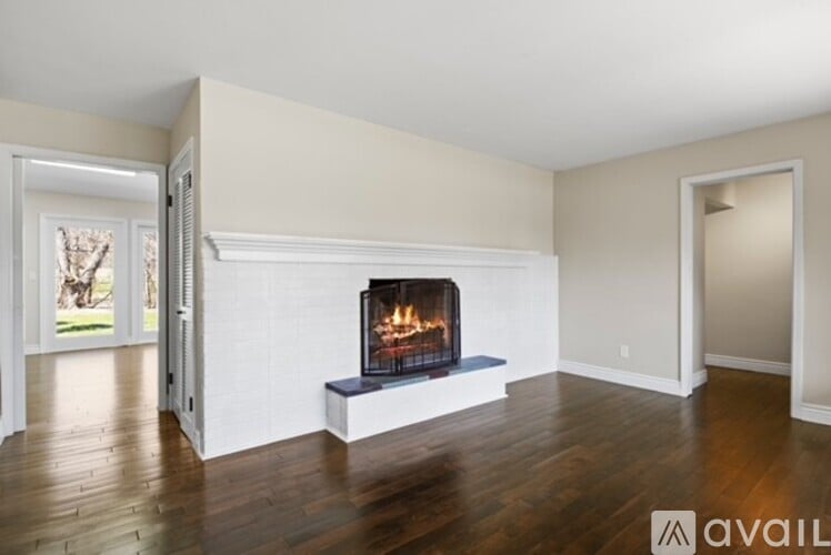 A living room with a fireplace and wood floors.