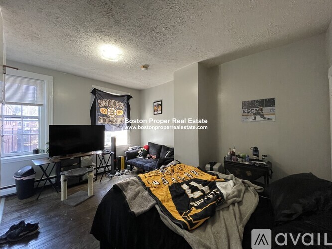 A bedroom with a Boston Bruins banner on the wall.
