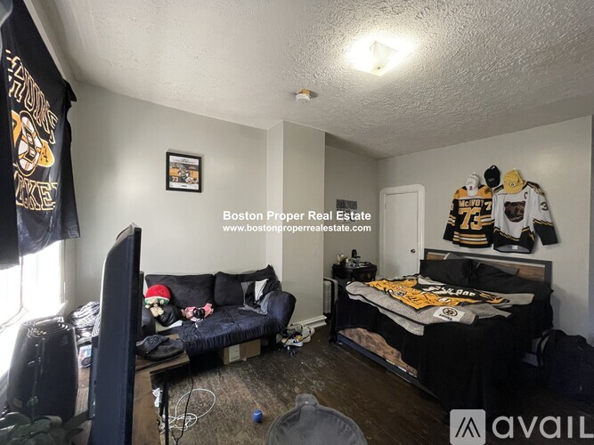 A room with a bed, couch, and chair in it.