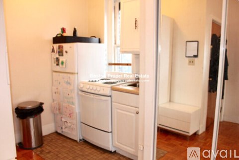 A small kitchen with a white fridge, white oven, and a white stove.