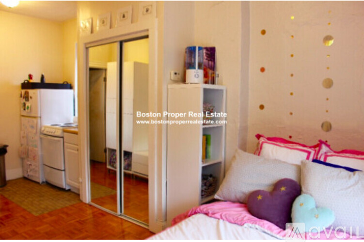 A bedroom with a bed, a dresser, and a mirror.