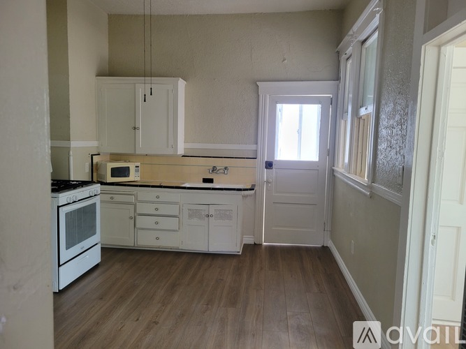 A kitchen with white cabinets and a microwave above the stove.