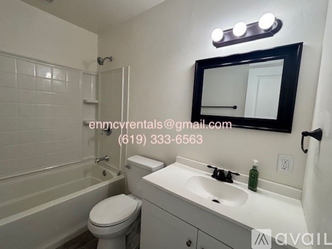 A bathroom with a toilet, sink, and mirror.