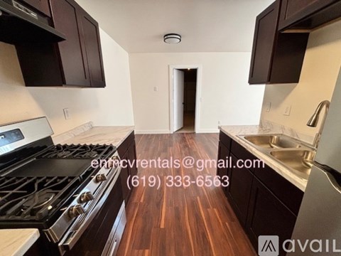 A kitchen with dark wood cabinets and a stove top oven.