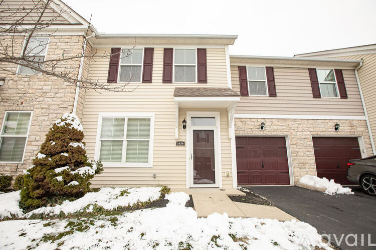 A house with a brown door and a garage door.