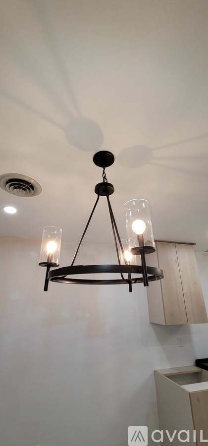 A chandelier with three lights hanging from the ceiling.