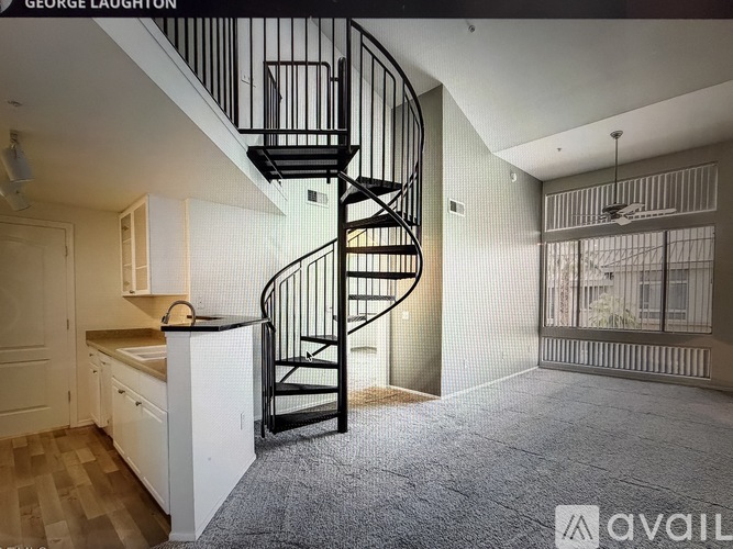 A spiral staircase in a modern kitchen with a view of the outdoors.