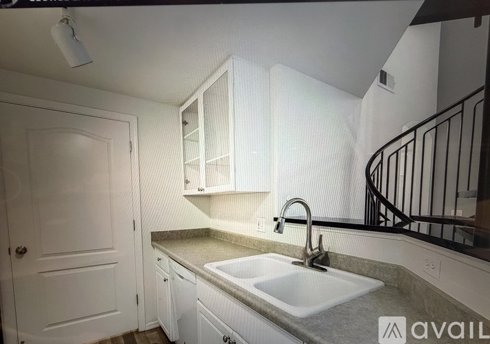 A kitchen with white cabinets and a white sink.