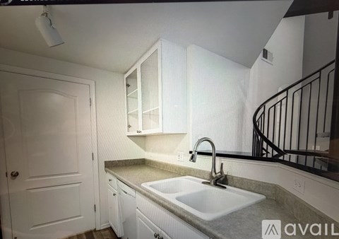 A kitchen with white cabinets and a white sink.