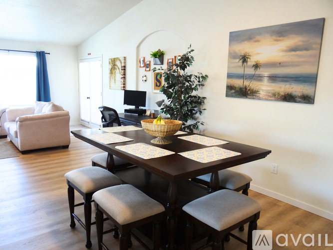 A dining room with a wooden table and chairs.