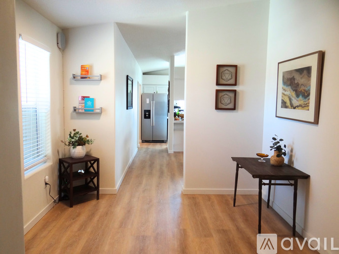 A hallway with a table and a framed picture on the wall.