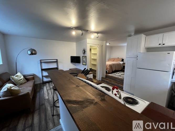 A kitchen with a brown countertop and white cabinets.