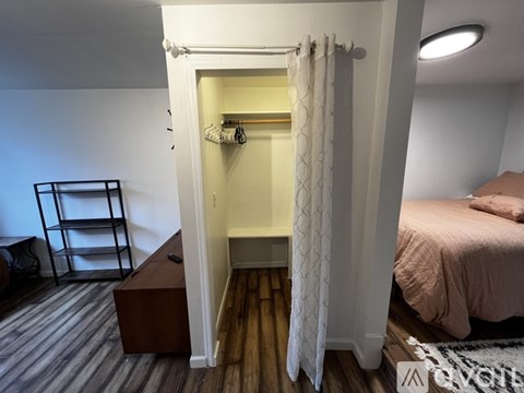 A bedroom with a bed, a wardrobe, and a bench.
