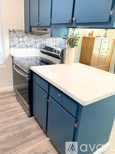 A kitchen with blue cabinets and a white countertop.