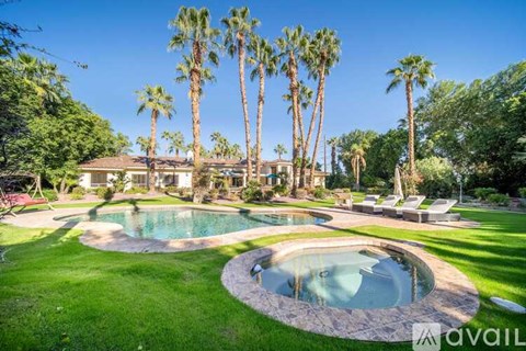A house with a pool surrounded by palm trees.