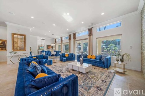 A living room with blue couches and a rug.